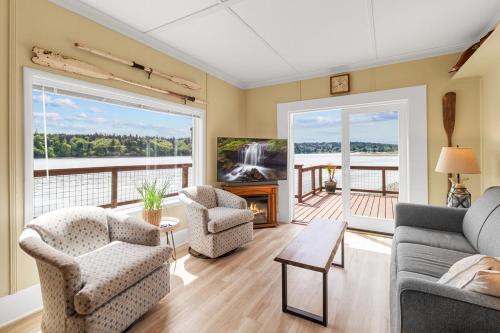 a living room with a couch and chairs and a tv at Charming Beach Cabin in Quartermaster Harbor in Vashon