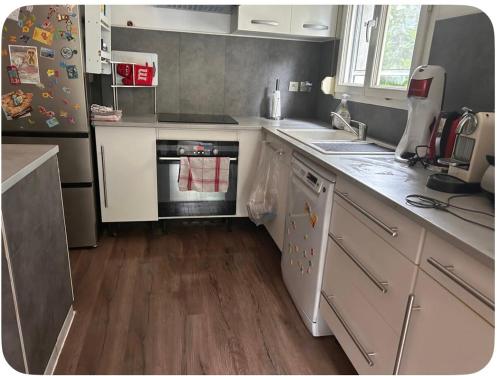 une cuisine avec un évier et une cuisinière four supérieur dans l'établissement T3 charmant petit nid douillet, à Eysines