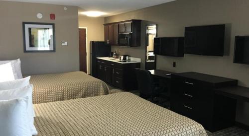 a hotel room with two beds and a desk at Americas Best Value Inn & Suites in Horn Lake