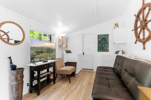 a living room with a couch and a desk at Charming Beach Cabin in Quartermaster Harbor in Vashon