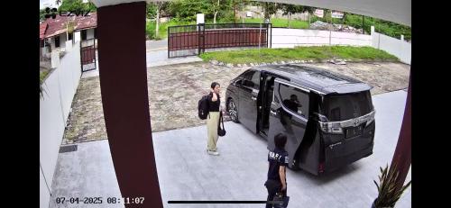 a woman is standing next to a bus at Villa Dwikora Pekanbaru in Pekanbaru