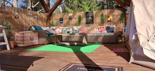 a patio with a couch and a green rug at Miami Jungle Glamping in Korjuse
