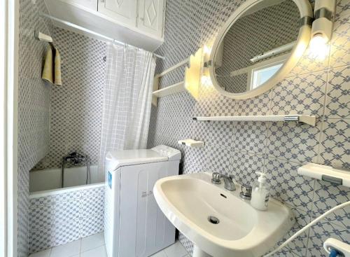 un bagno bianco con lavandino e specchio di La Casa degli Affreschi a Sperlonga