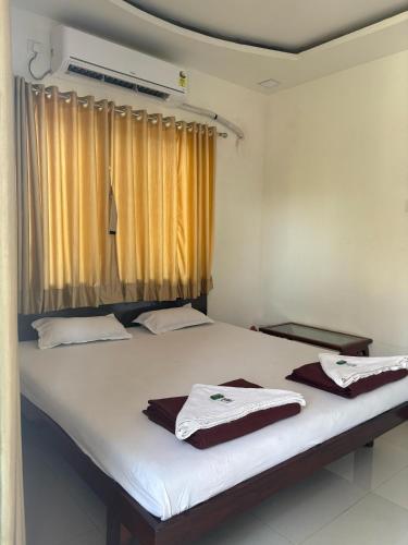 ein Schlafzimmer mit einem Bett mit weißen Laken und einem Fenster in der Unterkunft Raya Retreat Resort in Alībāg