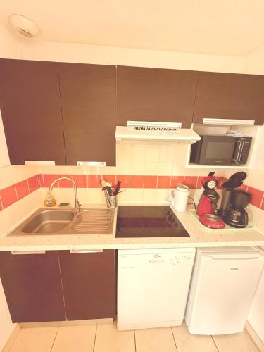 a small kitchen with a sink and a microwave at Villa le Castellet et proche circuit Paul-Ricard à 20 mn de la Mer in Signes