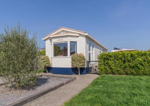 a small white house with a window in a yard at Chaletparc Krabbenkreek Zeeland - Chalet 110 in Sint Annaland