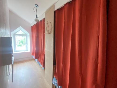 a room with red curtains and a window at Chez Catherine in Vorey