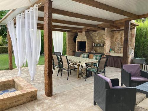 a patio with a table and chairs and a kitchen at La Huerta in Alcañiz
