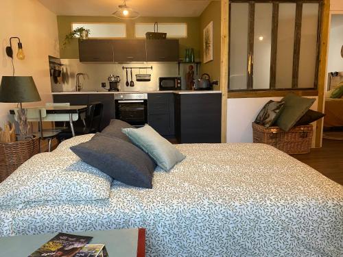 a bedroom with a bed with a kitchen in the background at Chez Catherine in Vorey