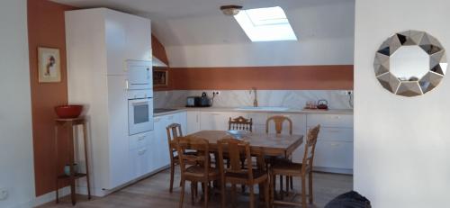 a kitchen with a table and chairs in a kitchen at Chez Catherine in Vorey