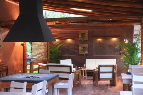 a patio with white chairs and tables and a black lamp at La Bicok EcoLodge in Mindo