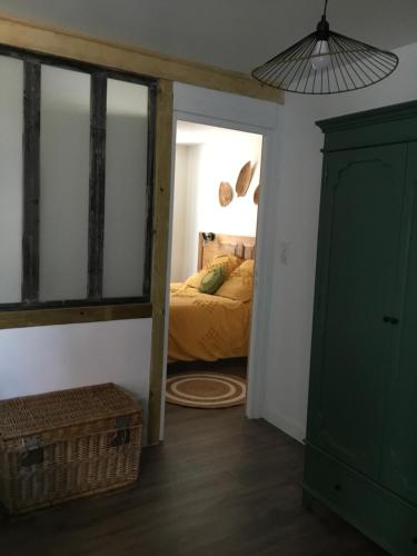 a bedroom with a bed and a green cabinet at Chez Catherine in Vorey