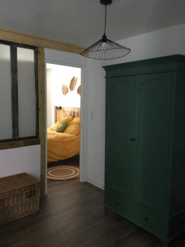 a bedroom with a green cabinet and a bed at Chez Catherine in Vorey