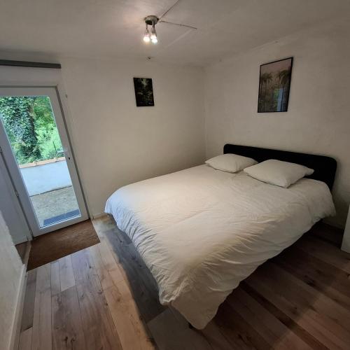 une chambre avec un grand lit blanc et une fenêtre dans l'établissement Le six cent dix huit, à Mauves-sur-Loire