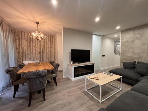 a living room with a couch and a table at Villa Aneto - Confort moderno en el corazón de Benasque in Benasque
