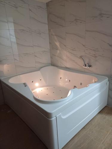 a white bath tub sitting in a bathroom at Prenoćište Silver Lux Srebrno Jezero 11 in Veliko Gradište