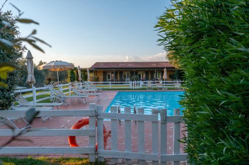 a pool with chairs and a house in the background at Agriturismo Podere L'Agave in San Vincenzo