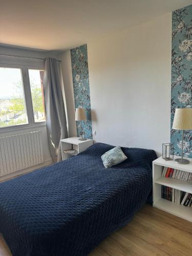 une chambre avec un lit bleu et une fenêtre dans l'établissement Entre mer et montagne, à Maureilhan-et-Raméjan