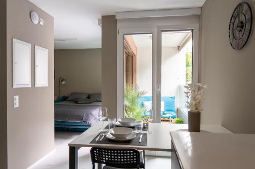 a dining room with a table and a bedroom at Locarno Center - Free Parking, Netflix and WiFi in Locarno