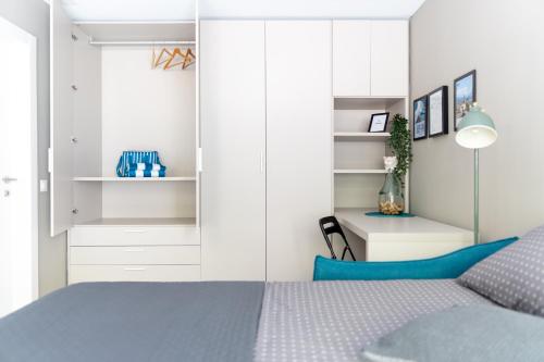 a bedroom with a blue bed and white cabinets at Locarno Center - Free Parking, Netflix and WiFi in Locarno
