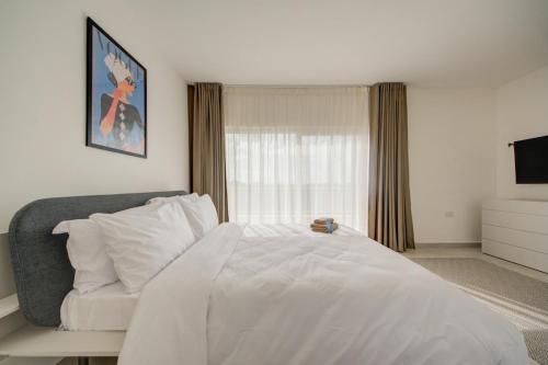 a bedroom with a white bed and a couch at The Valley Collection - A25 - with Private hot tub in Xagħra