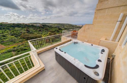 a hot tub on the balcony of a building at The Valley Collection - A25 - with Private hot tub in Xagħra