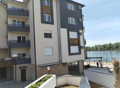 a building next to a body of water at Prenoćište Silver Lux Srebrno Jezero 11 in Veliko Gradište