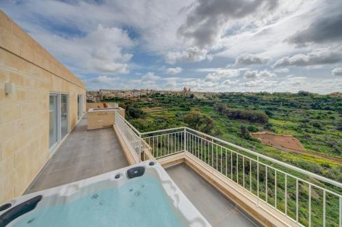 a balcony with a hot tub on top of a building at The Valley Collection - A25 - with Private hot tub in Xagħra