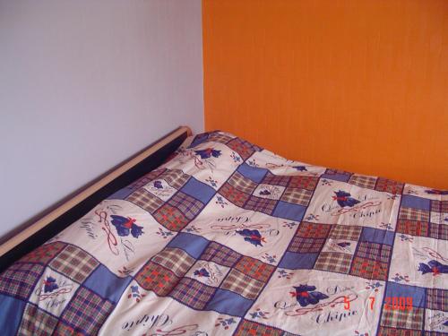 a bed with a quilt on it in a room at Entre mer et centre-ville in La Tranche-sur-Mer