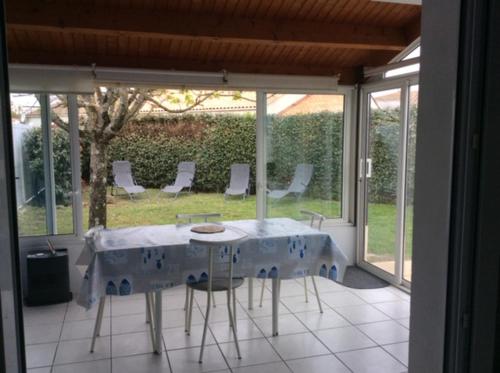 a room with a table and chairs on a patio at Entre mer et centre-ville in La Tranche-sur-Mer