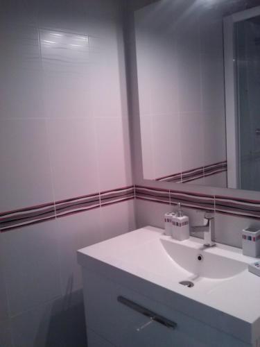 une salle de bain avec un lavabo blanc et un miroir dans l'établissement Entre mer et centre-ville, à La Tranche-sur-Mer
