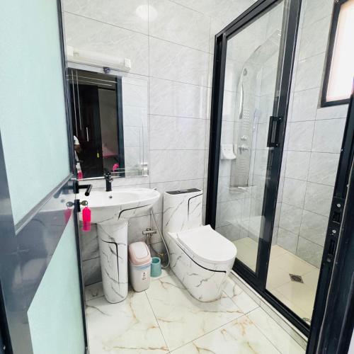 a bathroom with a toilet and a sink and a shower at Cité la vie in Douala