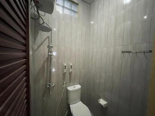 a bathroom with a shower and a toilet in it at D'Dalem Kadipaten Homestay in Yogyakarta
