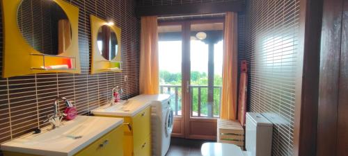 baño con 2 lavabos y ventana en Apartamentos Rosa Jove, en Cabañas