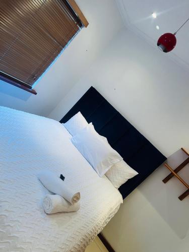 a bedroom with a bed with white sheets and pillows at AFRICAN HAVEN GUEST HOUSE BnB GOODWOOD in Cape Town