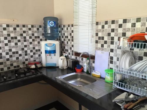 a kitchen counter with a sink and a mixer at Ratna Villa in Ubud