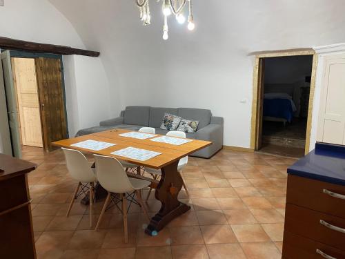 a dining room with a table and a couch at PIAZZETTA DEL FORNO appartamento in Assergi