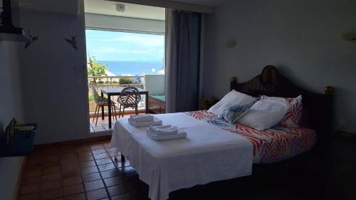 a bedroom with a bed with a view of a balcony at 135_ananas_bdg in La Trinité
