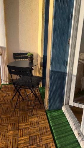 un balcon avec une table et des chaises et un sol vert dans l'établissement Appartement 2 chambres, centre ville, proche mer, à Saint-Nazaire
