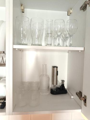 a cupboard filled with wine glasses and a blender at Angel U Guest House in K'obulet'i