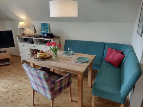 a living room with a table and a blue couch at Leuchtturm in Büsumer Deichhausen