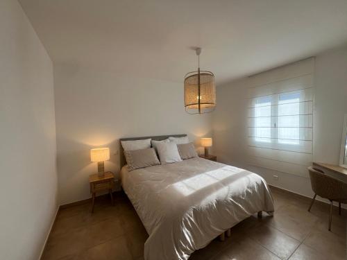 une chambre avec un lit avec deux lampes et une fenêtre dans l'établissement Appartement de standing Île-Rousse - Grande terrasse vue mer exceptionnelle, à LʼÎle-Rousse