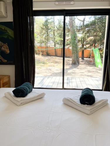 - un lit avec 2 serviettes vertes dans l'établissement Villa avec piscine, plage Sud, à Lacanau