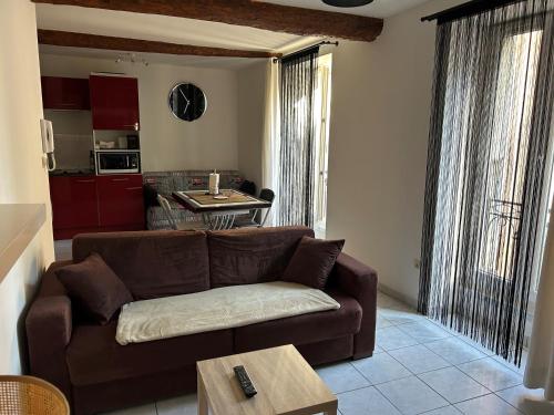 un salon avec un canapé marron et une table dans l'établissement Appartement-Studio, à Sérignan