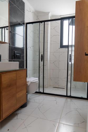 a bathroom with a shower and a sink and a toilet at Villa Begonvil in Sogut