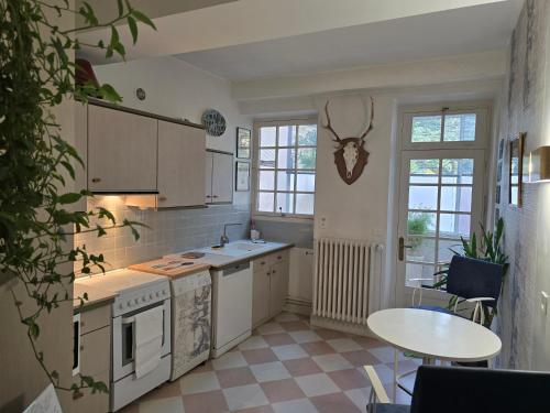 una cucina con elettrodomestici bianchi, tavolo e sedie di Bel appartement a Beaune