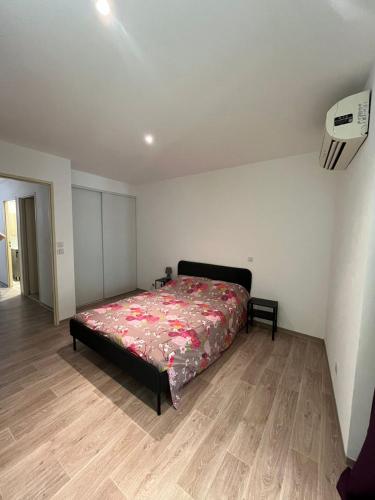 une chambre avec un lit et un parquet dans l'établissement Le magasin, à Argelès-sur-Mer