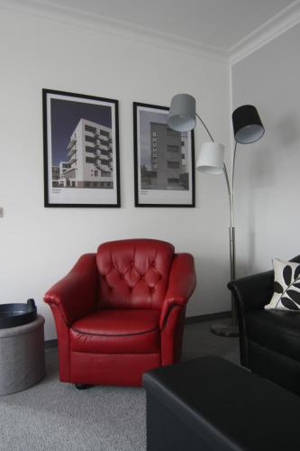 a living room with a red chair and a lamp at Wohnung in Stadtvilla, Dessau-Ziebigk in Dessau