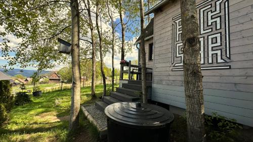 a house with a trash can in front of it at Privátní wellness domek RockStar in Smržovka