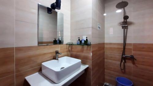 a bathroom with a white sink and a shower at NEST House in Ấp Kim Thạch